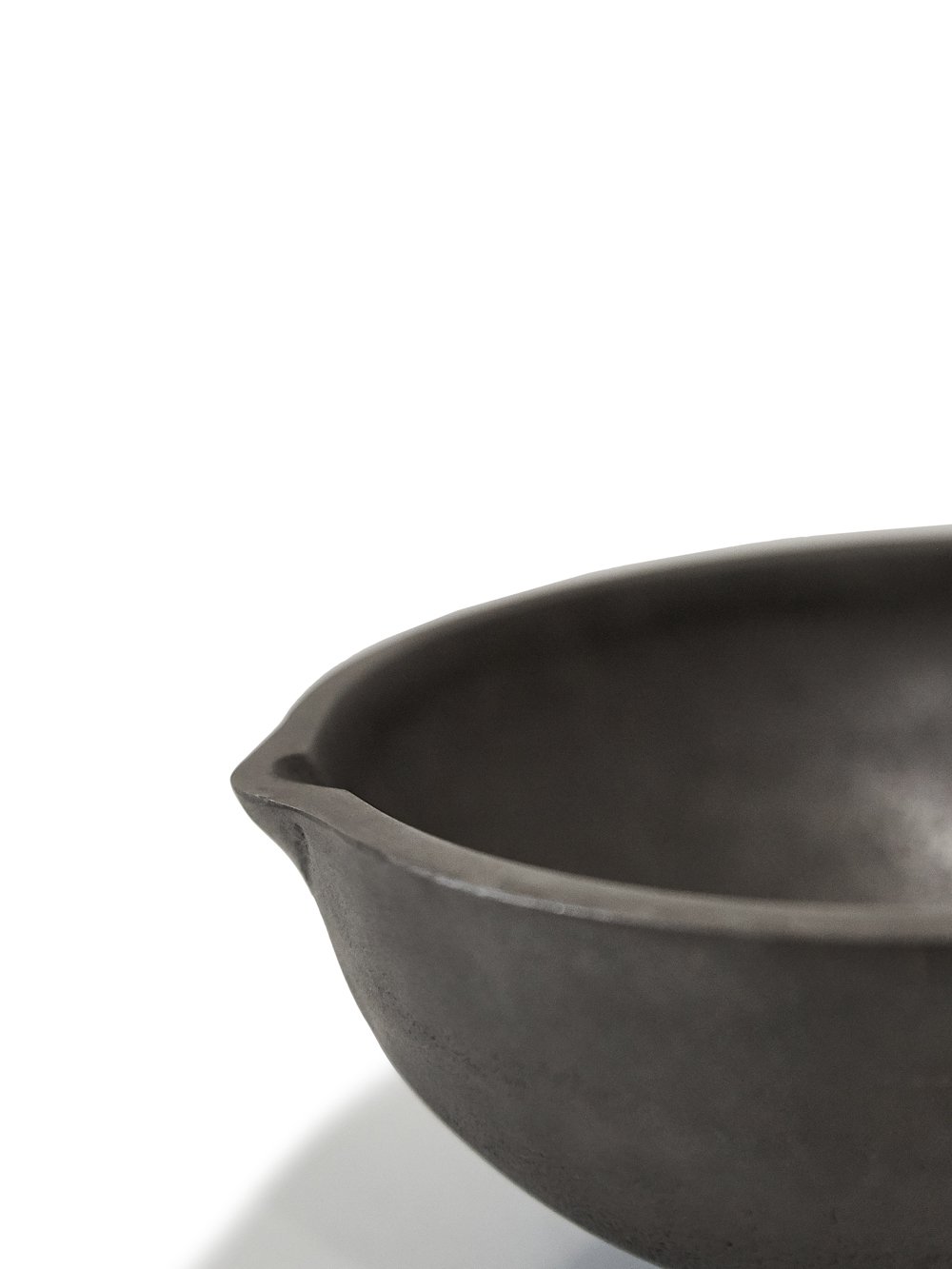 RICK OWENS BOWL HAS A ROUND SHAPE AND FEATURES A SMALL TRIANGLE DETAIL AND POLISHED SURFACE.